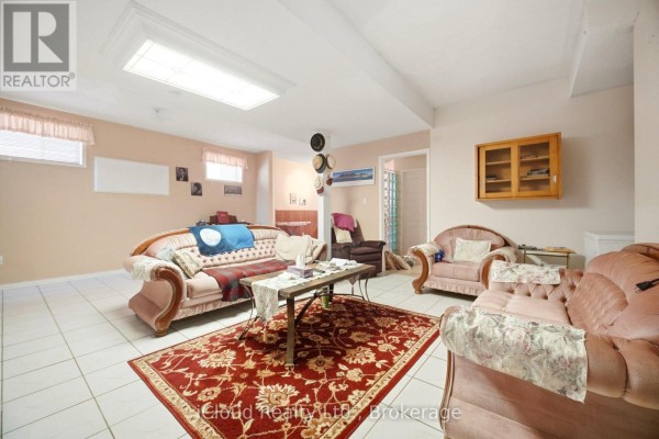 Living room with tufted sofas, red patterned rug, coffee table, and skylight - 6332 Glen Meadows Road Mississauga