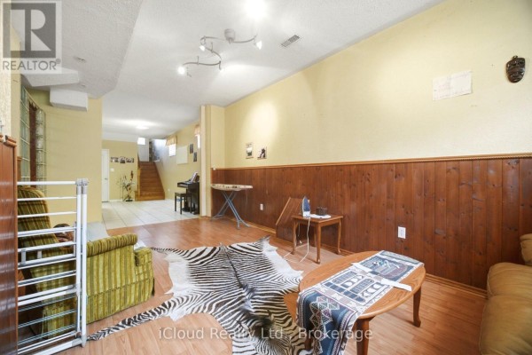 Finished basement living room with zebra rug, piano, and wood paneling - 6332 Glen Meadows Road Mississauga