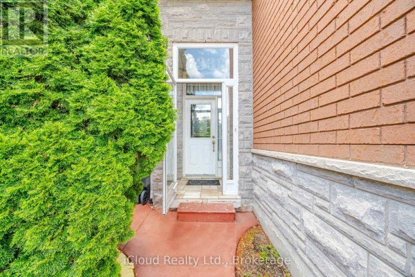 Close-up of the front entrance with a white door, glass sidelights, and brick facade. - 6332 Glen Meadows Road, Mississauga