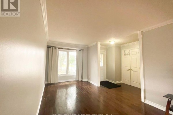 View of the entryway and living room with hardwood floors and crown molding. - 6337 Martel Court, Mississauga