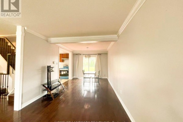Open-concept living and dining area with dark hardwood floors and a doorway to the kitchen. - 6337 Martel Court, Mississauga