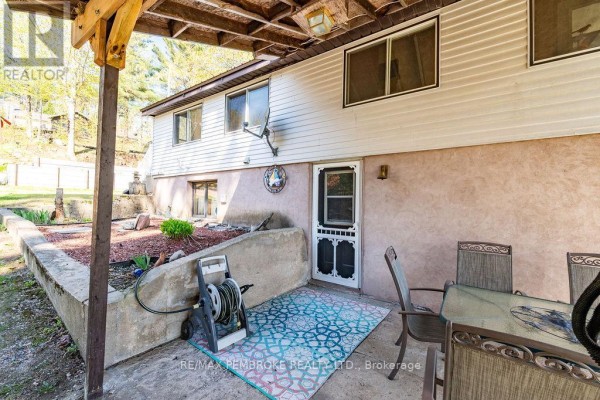 Back patio area with concrete floor, outdoor table and chairs, and a storage shed. - 634 Goldfinch Way, Head, Clara And Maria