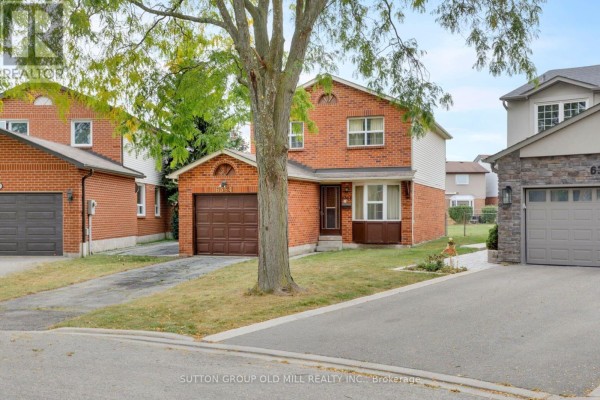Street view of the red brick house with a garage and mature trees. - 6364 Plowmans Heath, Mississauga