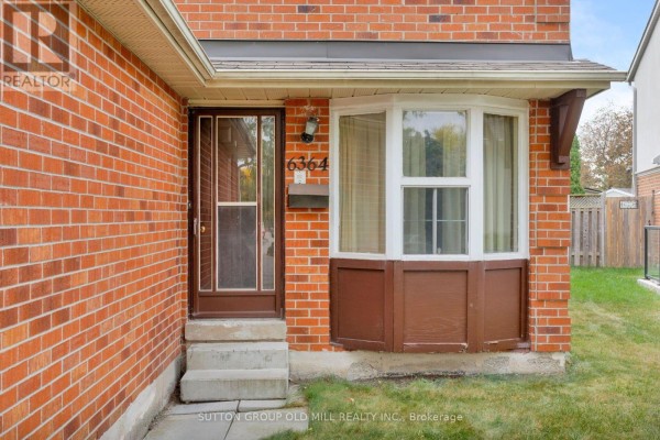 Close-up of the front door and bay window of the red brick house. - 6364 Plowmans Heath, Mississauga