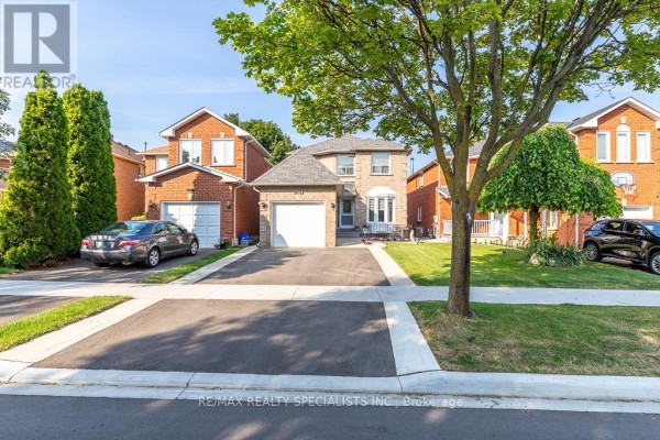 Street view of a brick house with a well-maintained lawn, driveway, and mature trees. - 6369 Longspur Road, Mississauga
