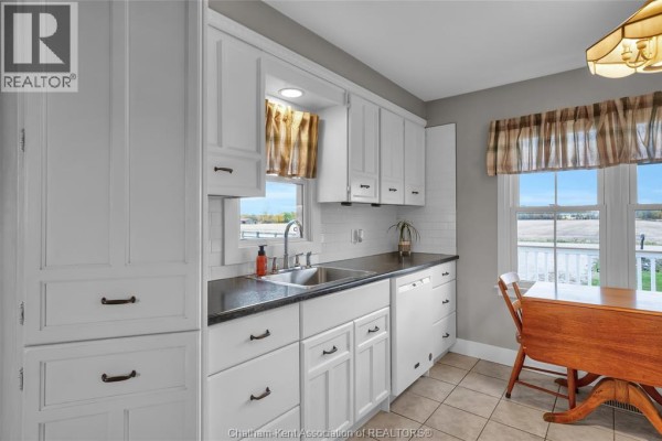 Bright kitchen with white cabinetry, dining table, and views of the outdoors. - 637 Wilkesport Line, Sombra