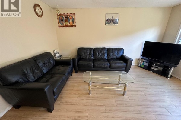 Living room with two black leather sofas, a glass coffee table, and wall art. - 6370 Park Drive Unit# 11, Oliver