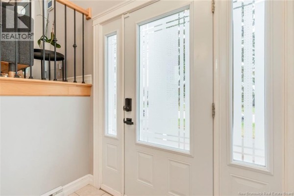 Interior view of a white front door with frosted glass panels and a staircase railing. - 638 Guy Avenue, Dieppe