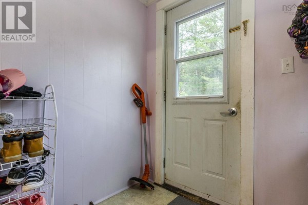 Mudroom with a white door, shoe rack, and garden tool. - 639 Faculty Drive, Greenwood
