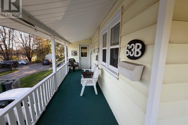 Covered porch area with white railings, a chair, and the number 63B. - 63a&b Brackley Point Road, Charlottetown