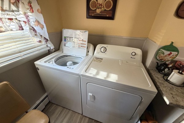 White top-load washing machine and front-load dryer in a laundry area. - 63a&b Brackley Point Road, Charlottetown