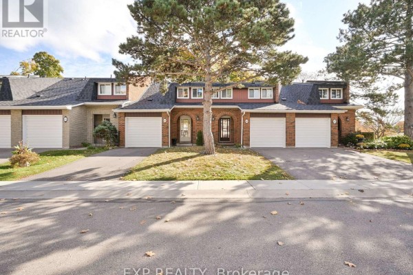 Front view of a row of brick townhouses with attached garages and manicured lawns. - 64 - 3351 Hornbeam Crescent N, Mississauga