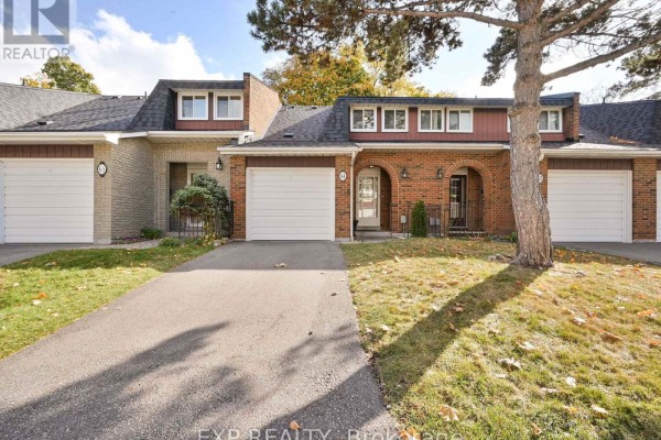 Exterior view of a townhouse complex with brick and light-colored siding, featuring garages and green lawns. - 64 - 3351 Hornbeam Crescent N, Mississauga