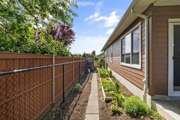 Open kitchen with dark wood cabinets, island seating, and dining area - 64 7600 Chilliwack River Road, Sardis East Vedder, Chilliwack