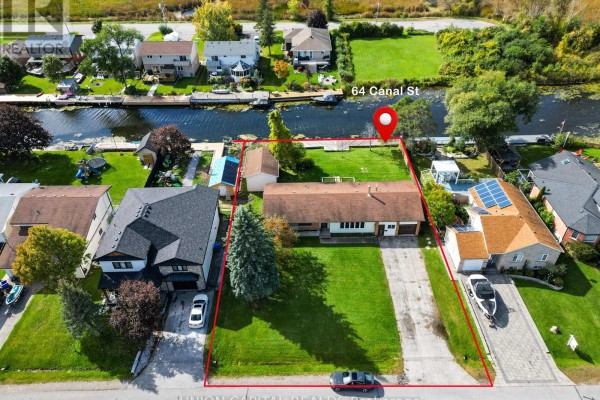 Aerial view of the 64 Canal Street property, with a bungalow, garage, and canal waterfront. - 64 Canal Street, Georgina