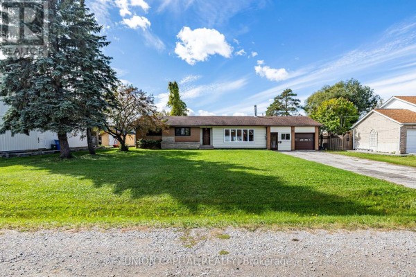 Front exterior of the 64 Canal Street bungalow with a lawn, driveway, and garage. - 64 Canal Street, Georgina