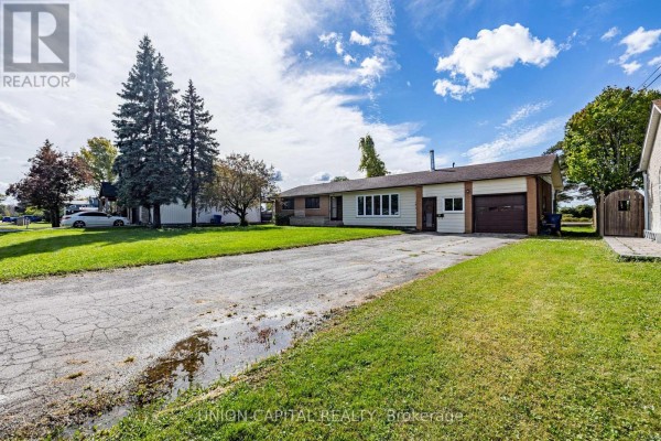 Side view of the 64 Canal Street bungalow, showing the driveway, lawn, and garage. - 64 Canal Street, Georgina