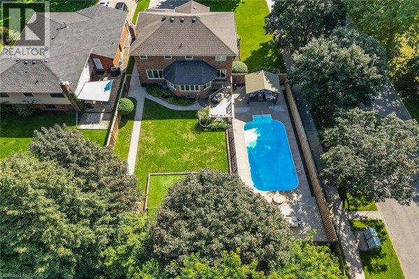 Aerial view of a large backyard with a swimming pool, patio, and green lawn. - 64 Driftwood Court, Grimsby