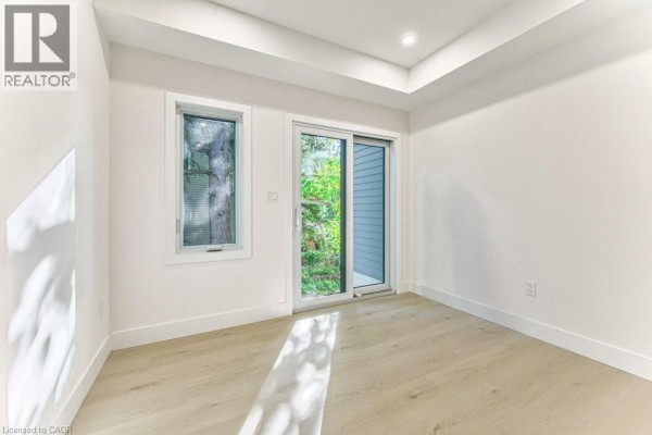Room with natural light, a sliding glass door, and a window with view of greenery. - 64 Gage Avenue Unit# 1, Kitchener