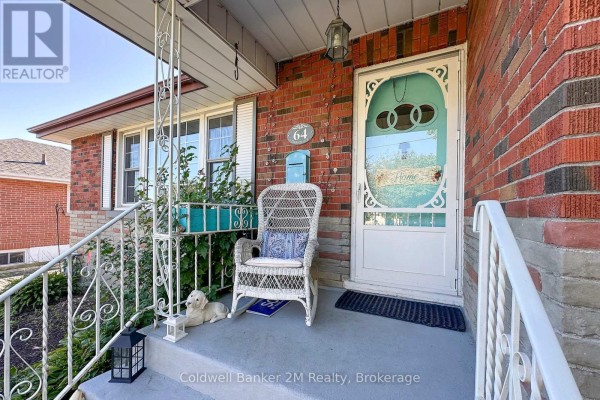 Close-up of a front porch with a white wicker chair, blue mailbox, and glass-paneled door. - 64 Harris Avenue, Oshawa