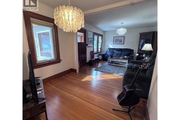 Another angle of the living room highlighting the chandelier and natural light. - 640 Wallinger Avenue, Kimberley