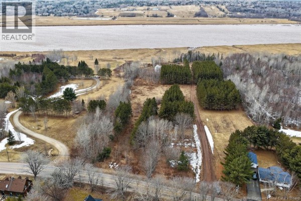 Aerial view of a wooded property with a dirt path, scattered snow, and bordering trees. - Lot 26-02 Dover Road, Dieppe