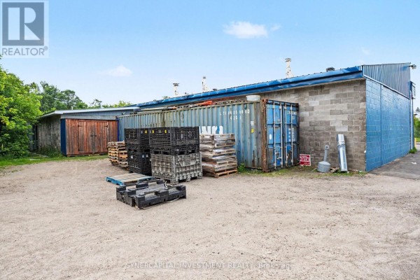 Storage area with shipping containers, plastic crates, and wooden pallets outside. - 641 Nelson Street, Pembroke