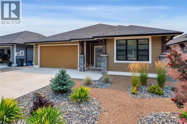 Close-up front view of a single-family home with tan siding and manicured landscaping. - 641 Shuswap Road E Unit# 228, Kamloops