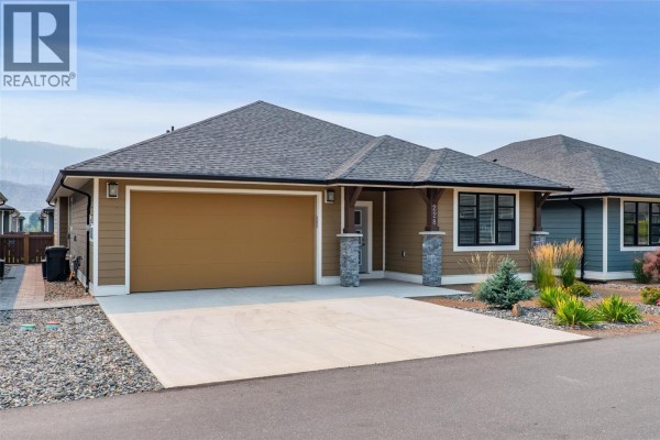 Exterior side view of a single-family home showing a garage and driveway. - 641 Shuswap Road E Unit# 228, Kamloops