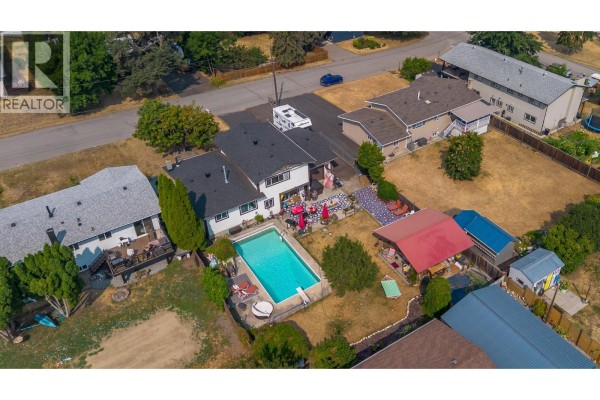Outdoor seating area with Adirondack chairs and a patterned rug in front of a wooden cabin. - 6415 Glendora Way, Lavington