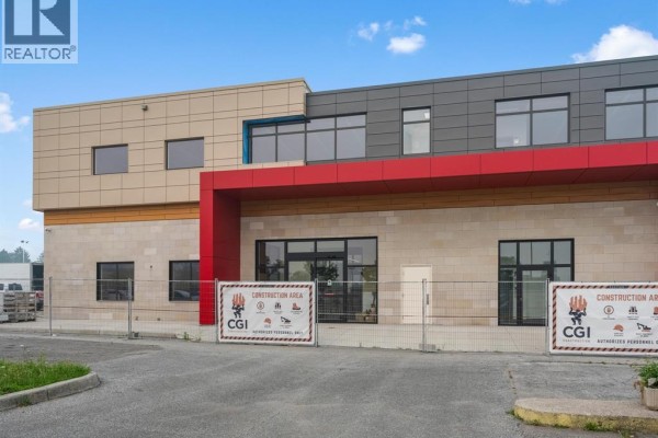 Close-up of the commercial building's entrance with glass doors and construction fencing. - 6415 Tecumseh Road East, Windsor
