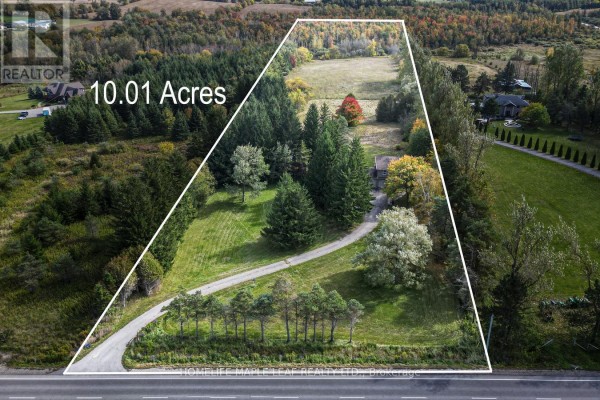 Aerial view of a 10.01-acre property with a house, treed areas, and open fields. - 64312 Dufferin County Road 3, East Garafraxa
