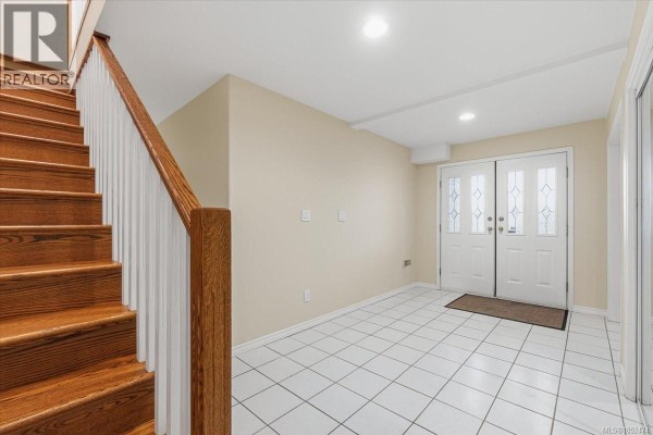 Bedroom with chandelier, large window, and neutral decor - 6439 Nidri Pl, Nanaimo