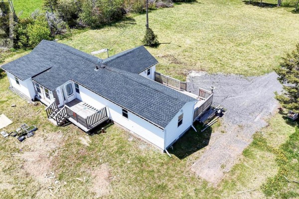 Aerial view of the rear of a white mobile home with two decks and a gravel driveway. - 6447 Cardigan Road, Cardigan
