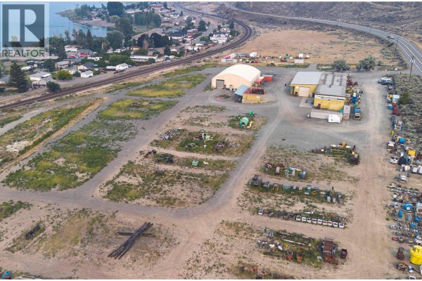 Aerial view showing buildings, tent structure, equipment yard, residential area, railroad tracks, and highway. - 6451 Trans Canada Highway, Kamloops