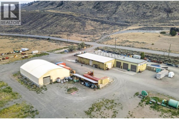 Aerial view of commercial buildings and tent structure with outdoor storage and surrounding undeveloped land. - 6451 Trans Canada Highway, Kamloops