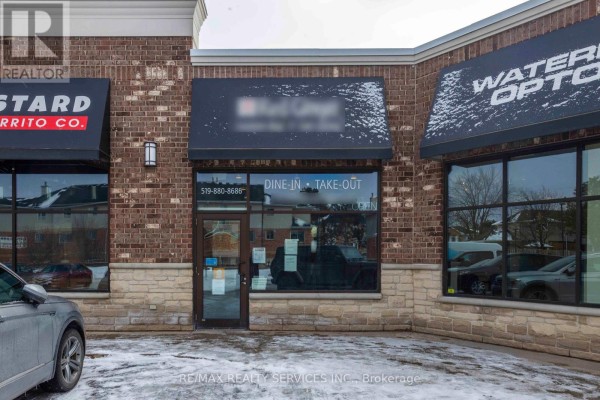 Front view of the 'Waterloo Optometry' entrance with snow on the ground and nearby signage. - 646 Erb St Street W, Waterloo