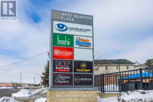 Signage for 'West Quarter Plaza' displaying various businesses including 'Waterloo West Optometry' and 'Fat Bastard'. - 646 Erb St Street W, Waterloo