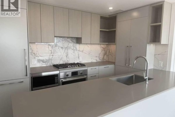 Open concept living and kitchen area with island, dining table, and sofa. - 6468 Willingdon Avenue, Burnaby
