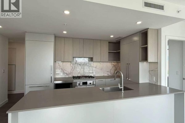Bedroom with a queen-size bed, plush pillows, and marble accent wall. - 6468 Willingdon Avenue, Burnaby