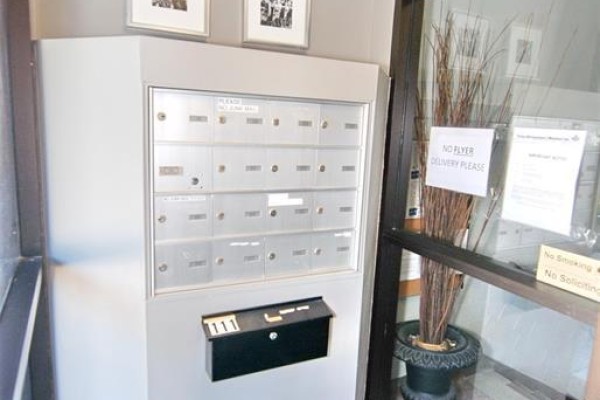Wall of mailboxes with individual numbered compartments and a black mailbox at the bottom. - 647 Irvine Avenue Unit# 301, Windsor