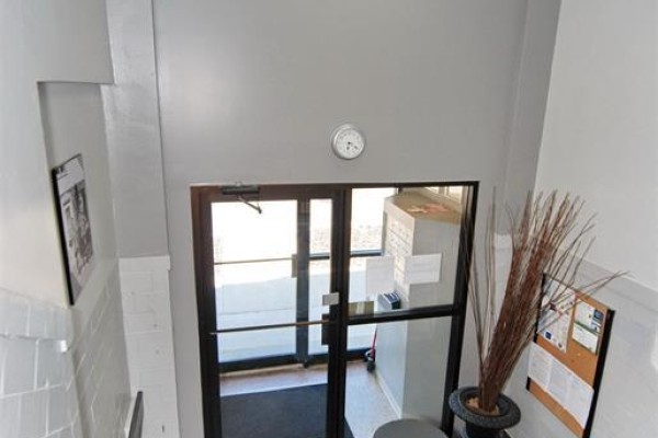 Interior view of the building entrance with glass doors, mailboxes, and decorative branches. - 647 Irvine Avenue Unit# 301, Windsor