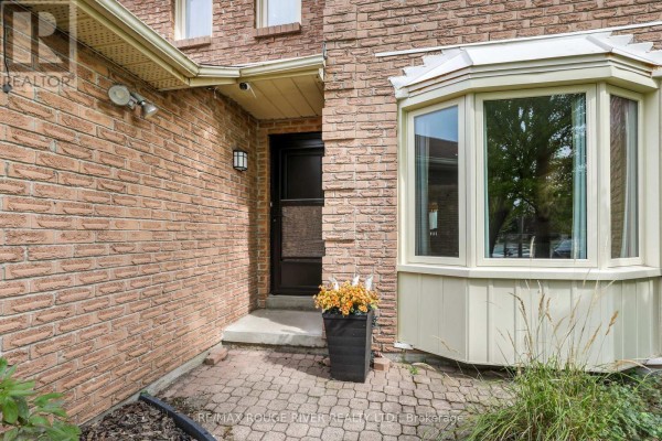 Close-up of the front entrance with brick exterior and bay window. - 648 Cognac Crescent, Pickering