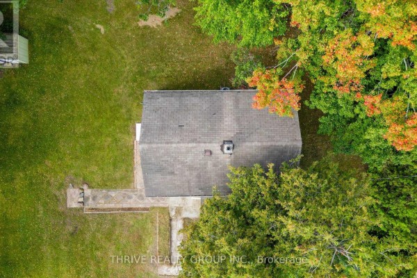 Rear exterior of a yellow house with a propane tank and a small shed in the yard. - 648 Concession 13 Concession, Norfolk