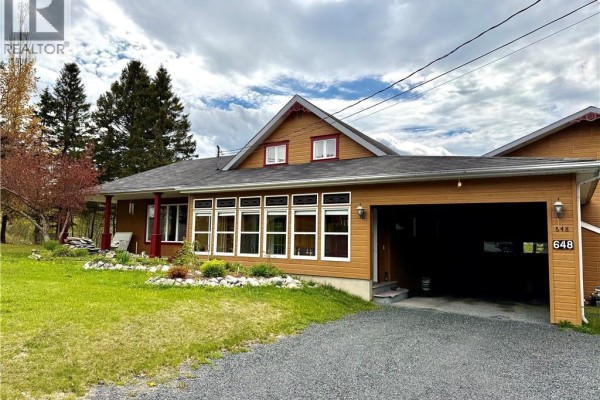 Side view of the house showing garage and snow-covered ground - 648 Toussaint Road, Saint Joseph