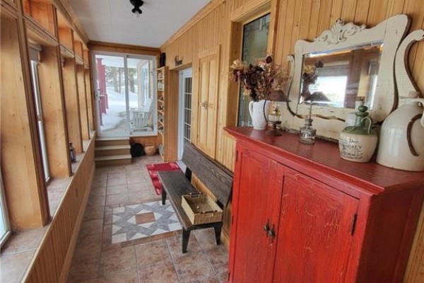 Corner view of the house with snow and wooden steps leading to the entrance - 648 Toussaint Road, Saint Joseph