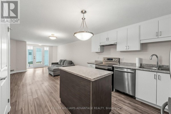 Open concept living area and kitchen with a grey sofa and French doors. - 64a - 1989 Ottawa Street S, Kitchener