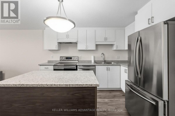 Close-up of the kitchen island with granite countertop and dark wood base. - 64a - 1989 Ottawa Street S, Kitchener