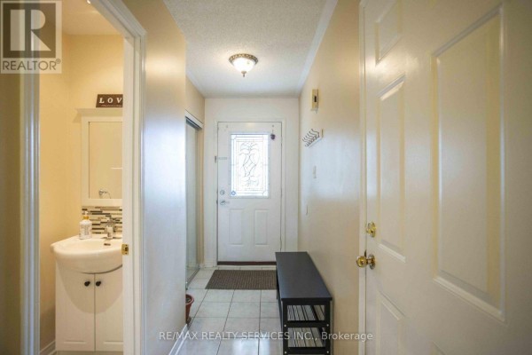 Interior entryway with tiled floor, white door, and small vanity. - 65 - 6830 Meadowvale Town Centre Circle, Mississauga