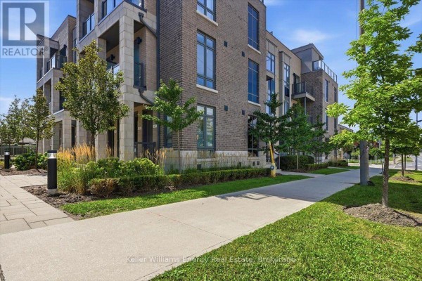 Townhouse exterior with brick facade, balconies, windows, and landscaped garden beds. - 65 - 721 Lawrence Avenue W, Toronto